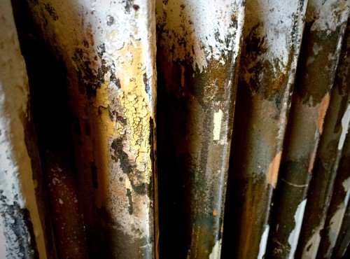 This is the backside of one of our radiators showing the dirt and layers of paint accumulated over decades. 