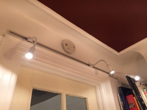 LED track lighting above the door to highlight art.
