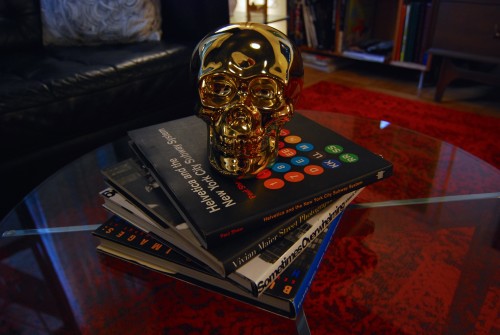 The ever changing stack of coffee table books guarded by our golden skull. (That book on the top is one of my favorites, I am such a Geek!)