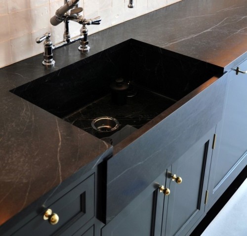 Soapstone counters.... Love them! In fact I love this whole set up with the dark cabinets and brass hardware. 