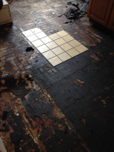 Shortly after moving in, we pulled up the peel-n-stick tile to reveal a layer of tar paper and what was once a very beautiful oak parquet floor.