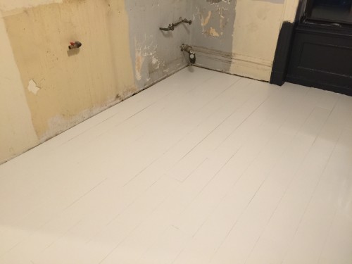 Once the damaged floor was repaired, we put down a temporary floor consisting of 1/4 inch plywood planks painted in white porch paint. The plan was to for it to last five years until we were ready to do our dream kitchen... Plans change.