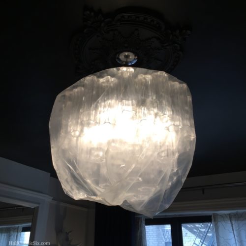 We wrapped our chandelier in a giant plastic bag to keep the dust at bay. Fortunately, the LED bulbs don't generate enough heat to be concerned about the plastic.