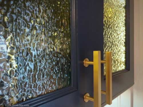 The interior cabinet lighting is just <a href="https://halfclassicsix.com/wp-content/uploads/2016/05/Upper-LED-Interior-Lighting.jpg" target="blank">inside the door frame</a> and wonderfully obscured by the texture in the glass.