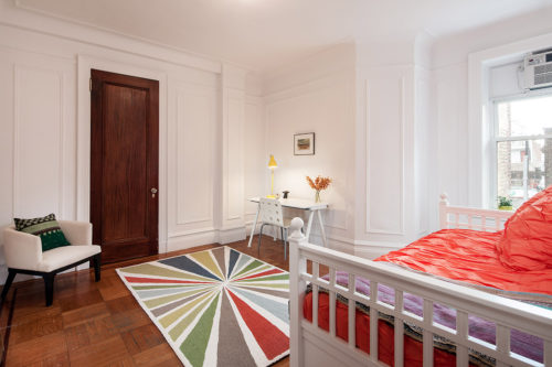The mahogany door in this lovely bedroom is a great example of what is lurking below the many layers of paint on our mahogany doors. (The panel molding on the walls is also really nice) [<i>Source: <a href="https://streeteasy.com/" target="blank">StreetEasy</a></i>]